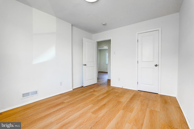 unfurnished bedroom featuring light wood-type flooring, visible vents, and baseboards