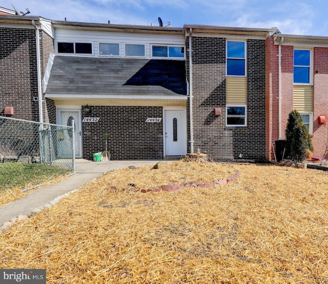 multi unit property featuring brick siding and fence