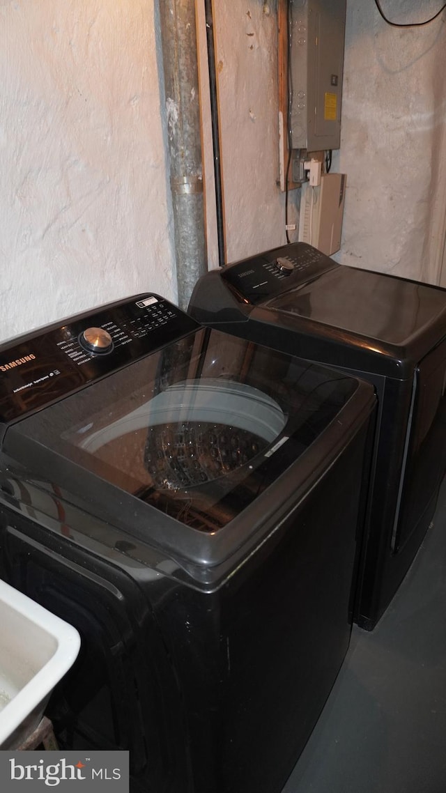 laundry room featuring laundry area, electric panel, and washing machine and clothes dryer