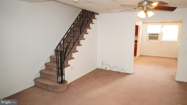 stairs featuring a paneled ceiling, carpet flooring, ceiling fan, cooling unit, and baseboards