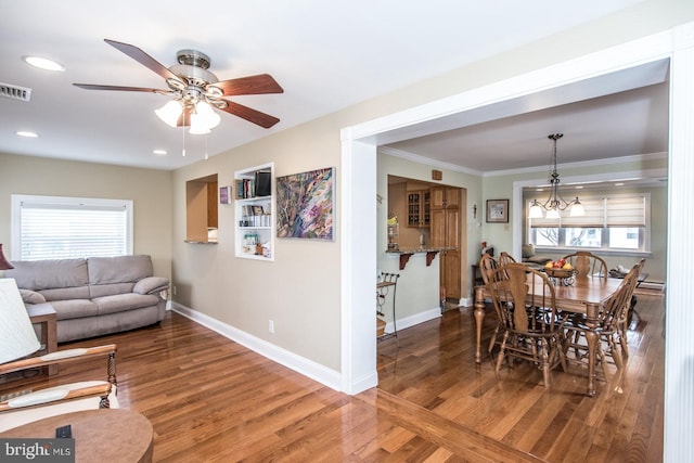 dining space with baseboards, wood finished floors, and a healthy amount of sunlight