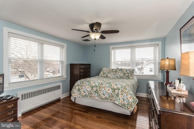 bedroom featuring dark wood-style floors, radiator heating unit, and baseboards