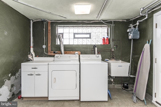 washroom with laundry area, a sink, and washer and dryer