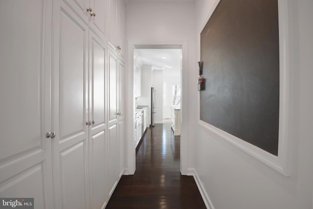 hallway with dark wood finished floors and baseboards