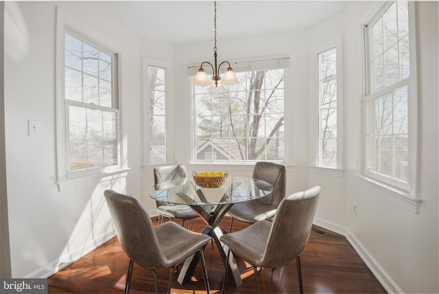 dining space with visible vents, baseboards, an inviting chandelier, and wood finished floors