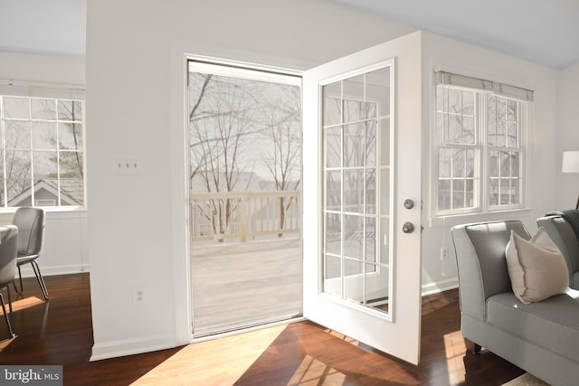 doorway with wood finished floors and baseboards