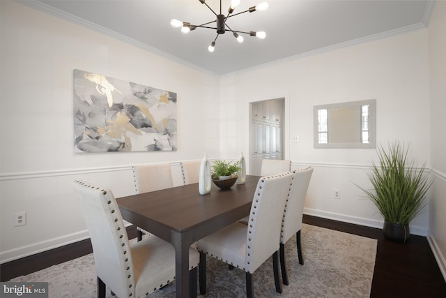 dining area with a chandelier, wood finished floors, baseboards, and ornamental molding