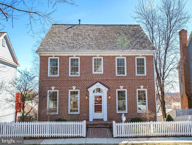 view of front of property with brick siding and a fenced front yard