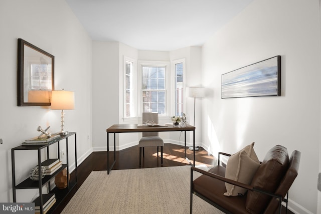 office space with baseboards and dark wood finished floors