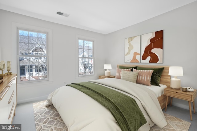 bedroom with visible vents, light carpet, and baseboards