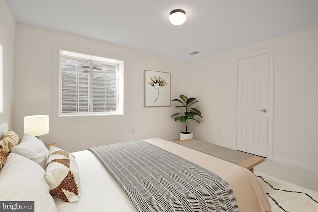 carpeted bedroom featuring baseboards and visible vents