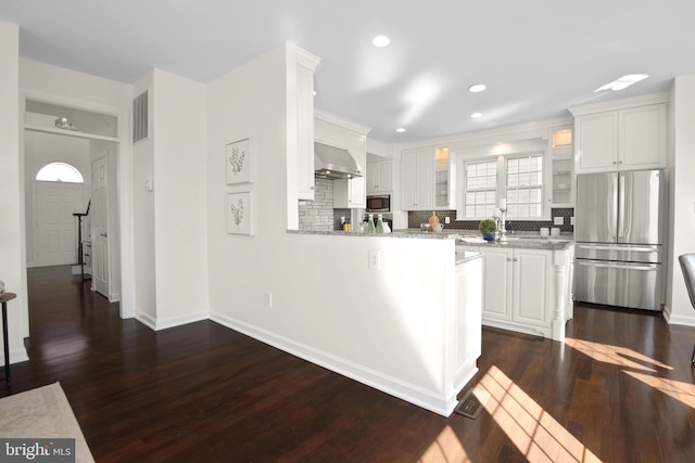 kitchen featuring white cabinetry, ventilation hood, visible vents, and appliances with stainless steel finishes