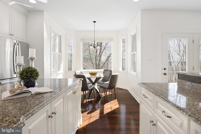 kitchen featuring white cabinetry, a healthy amount of sunlight, dark wood finished floors, and freestanding refrigerator