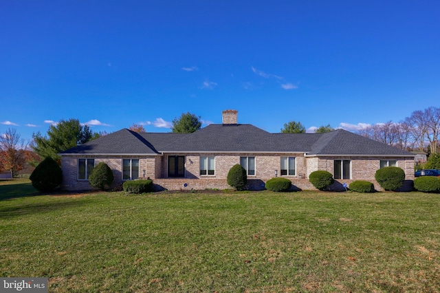 single story home featuring a front lawn, a chimney, and brick siding