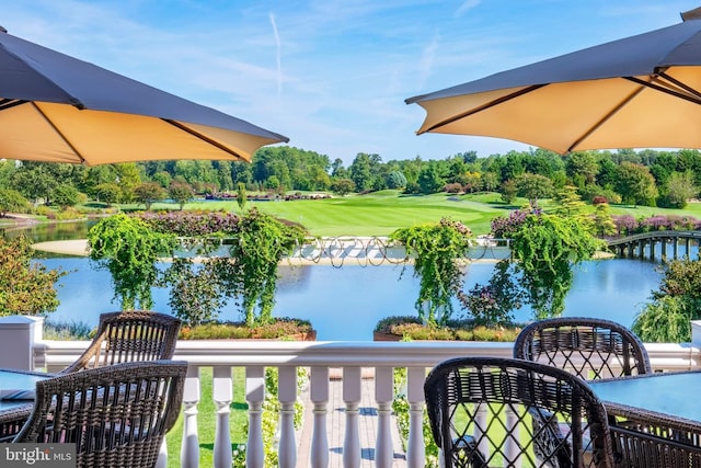 balcony featuring view of golf course and a water view