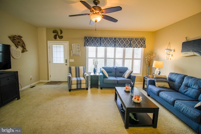 living room with ceiling fan, visible vents, and baseboards