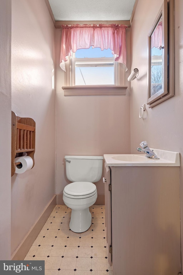 bathroom with baseboards, vanity, toilet, and tile patterned floors