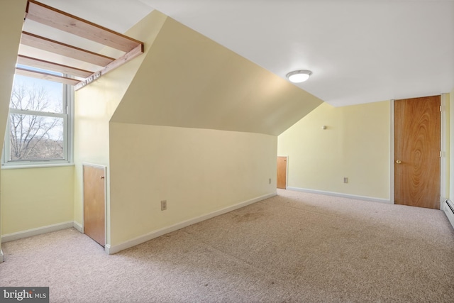 additional living space with carpet, baseboards, and vaulted ceiling