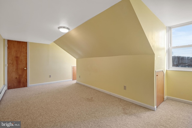 bonus room featuring light carpet, baseboards, and vaulted ceiling