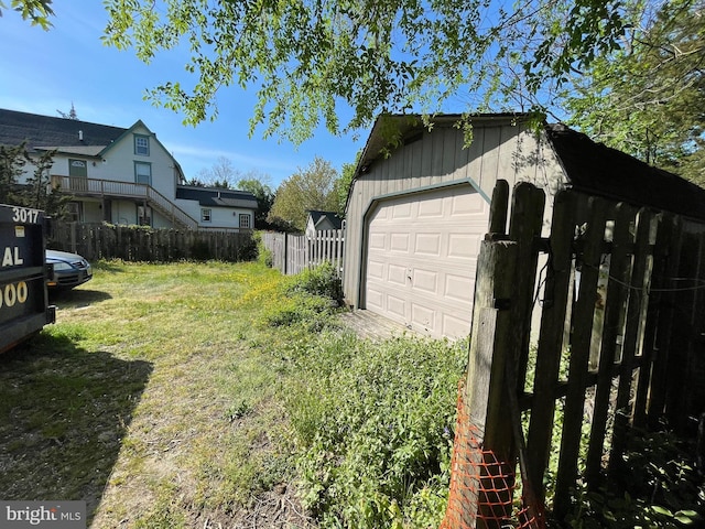 view of yard with a garage, fence, and an outdoor structure