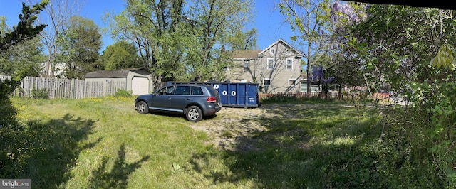 view of yard with a garage, an outdoor structure, and fence