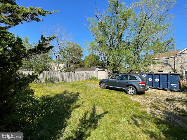 view of yard featuring a garage and fence