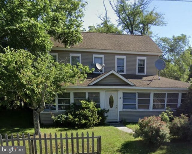 view of front of property with fence and a front lawn