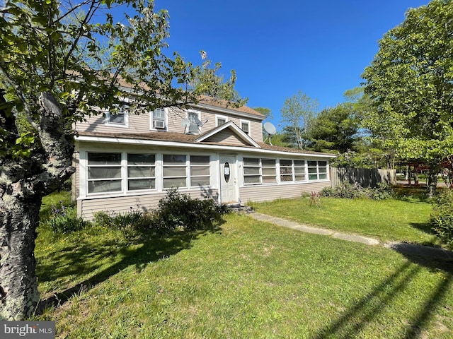 traditional-style home with fence and a front lawn