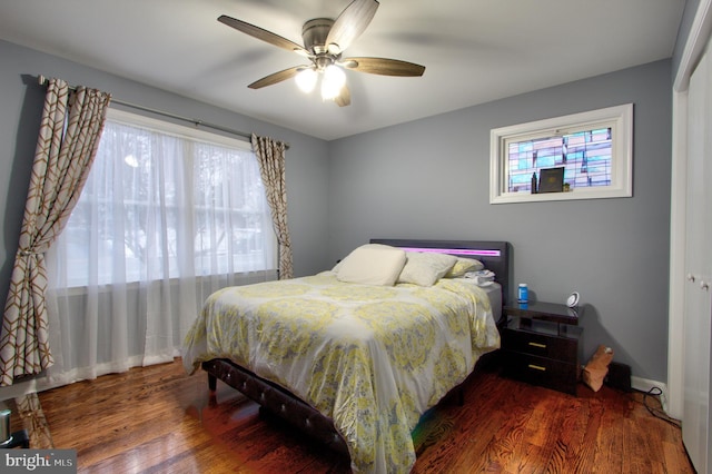 bedroom featuring ceiling fan, baseboards, and wood finished floors