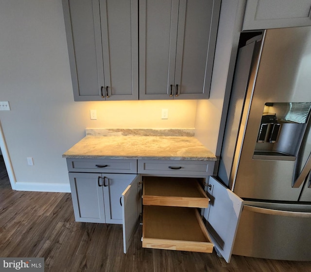 kitchen featuring gray cabinets, baseboards, stainless steel refrigerator with ice dispenser, and dark wood-type flooring