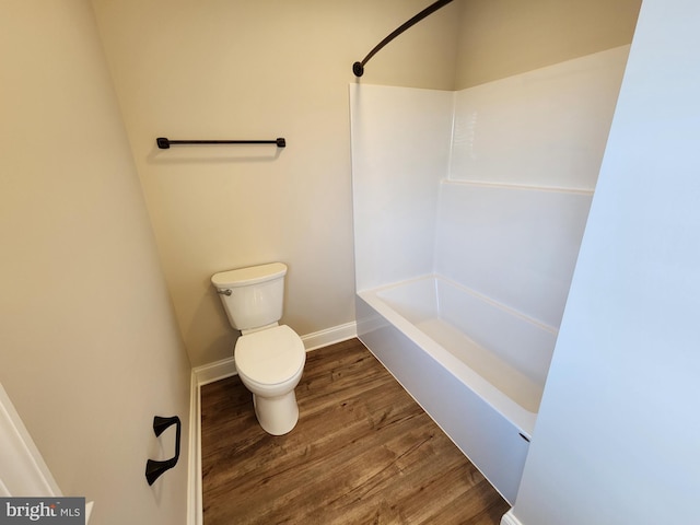 bathroom featuring bathtub / shower combination, wood finished floors, toilet, and baseboards