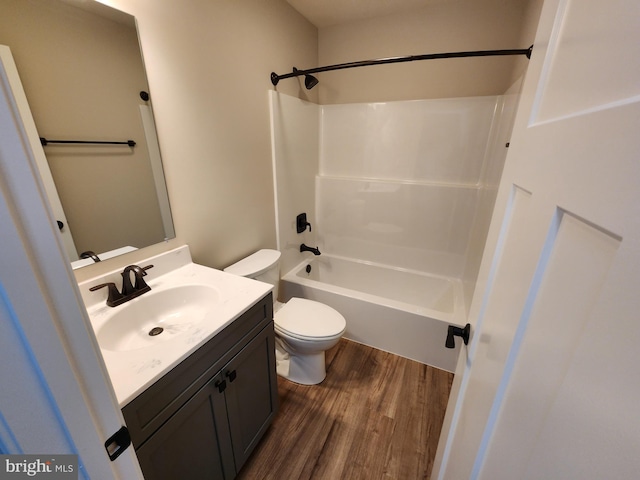 bathroom with vanity, shower / washtub combination, wood finished floors, and toilet