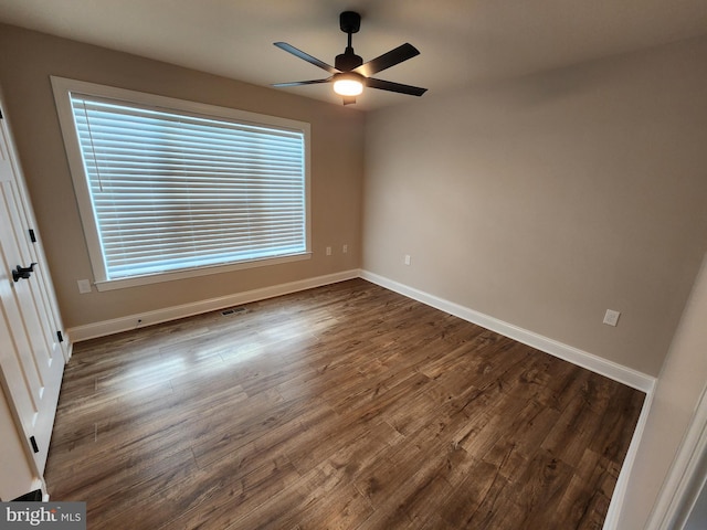 unfurnished bedroom with visible vents, dark wood finished floors, and baseboards