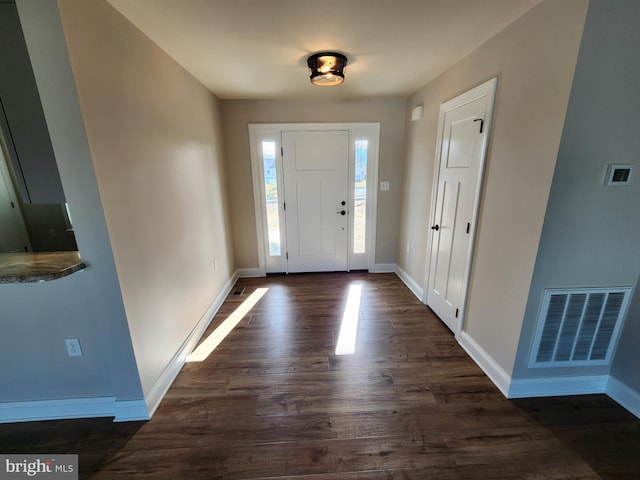 foyer entrance with baseboards, visible vents, and dark wood-style flooring