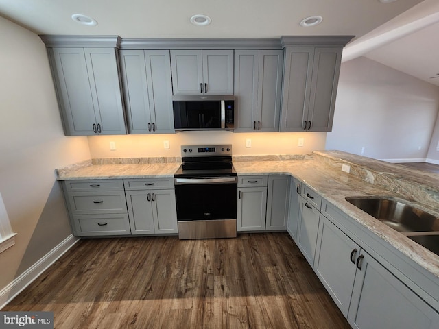 kitchen featuring dark wood-style floors, stainless steel appliances, recessed lighting, gray cabinetry, and light stone countertops