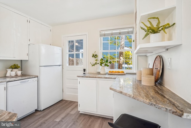 kitchen featuring light stone counters, open shelves, light wood-style flooring, white cabinets, and white appliances