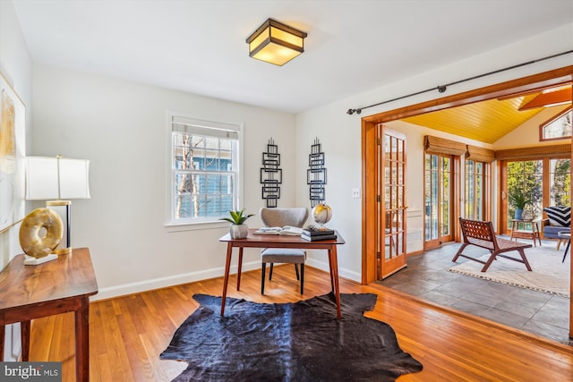 home office with wood-type flooring, baseboards, and vaulted ceiling