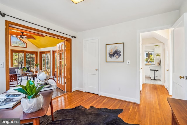 interior space featuring baseboards, vaulted ceiling, and hardwood / wood-style floors