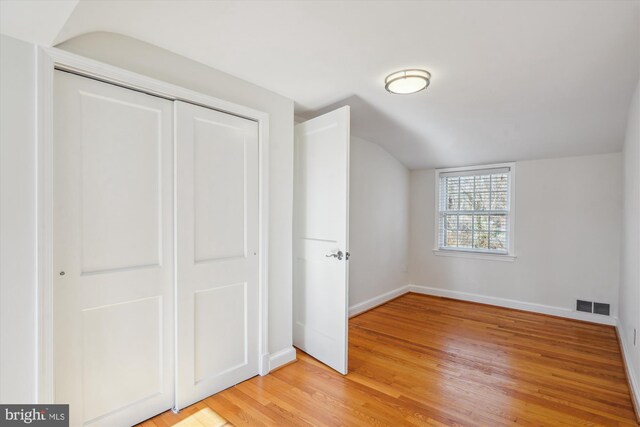 bonus room with light wood-style floors, visible vents, vaulted ceiling, and baseboards