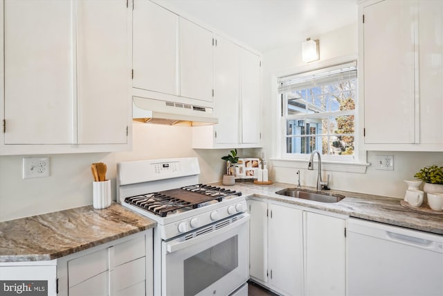 kitchen with under cabinet range hood, white appliances, a sink, white cabinets, and light stone countertops