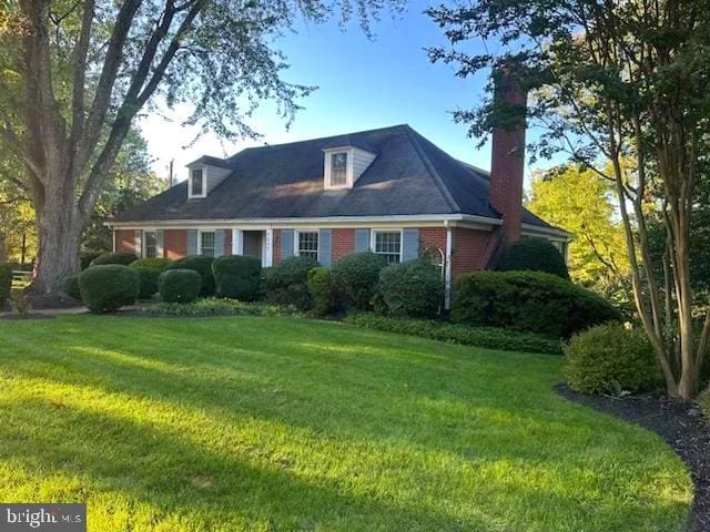 view of front of house featuring brick siding and a front yard