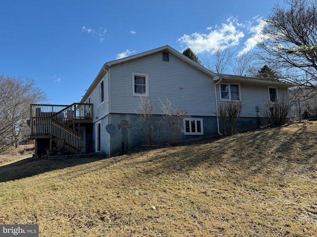 rear view of house with a deck, a yard, and stairway