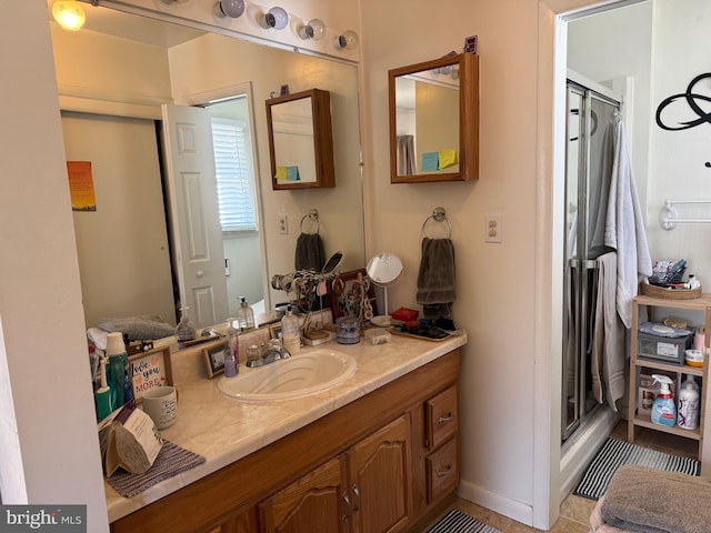 full bathroom featuring tile patterned flooring, a shower stall, and vanity