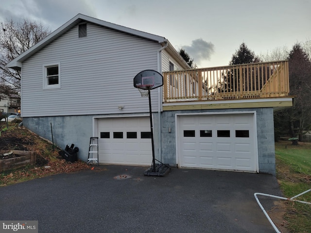 view of side of home featuring a garage and driveway