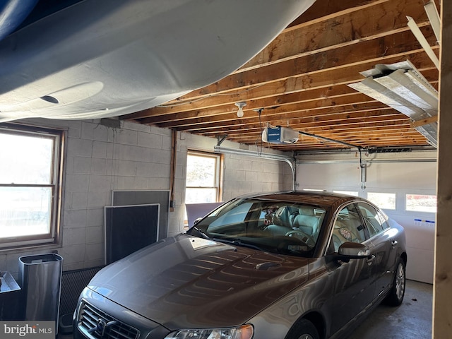 garage featuring a garage door opener and concrete block wall