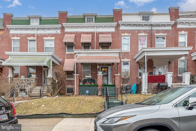 townhome / multi-family property with mansard roof and brick siding