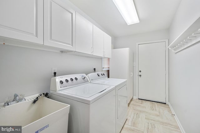 laundry room with independent washer and dryer, a sink, cabinet space, and baseboards