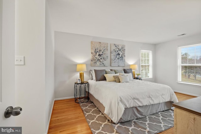 bedroom featuring baseboards, visible vents, and light wood-style floors