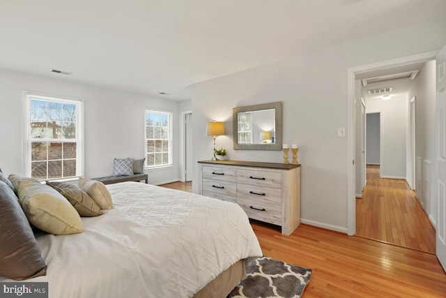 bedroom featuring light wood-type flooring, visible vents, and baseboards