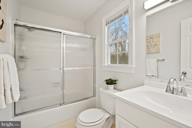 bathroom with toilet, combined bath / shower with glass door, and vanity